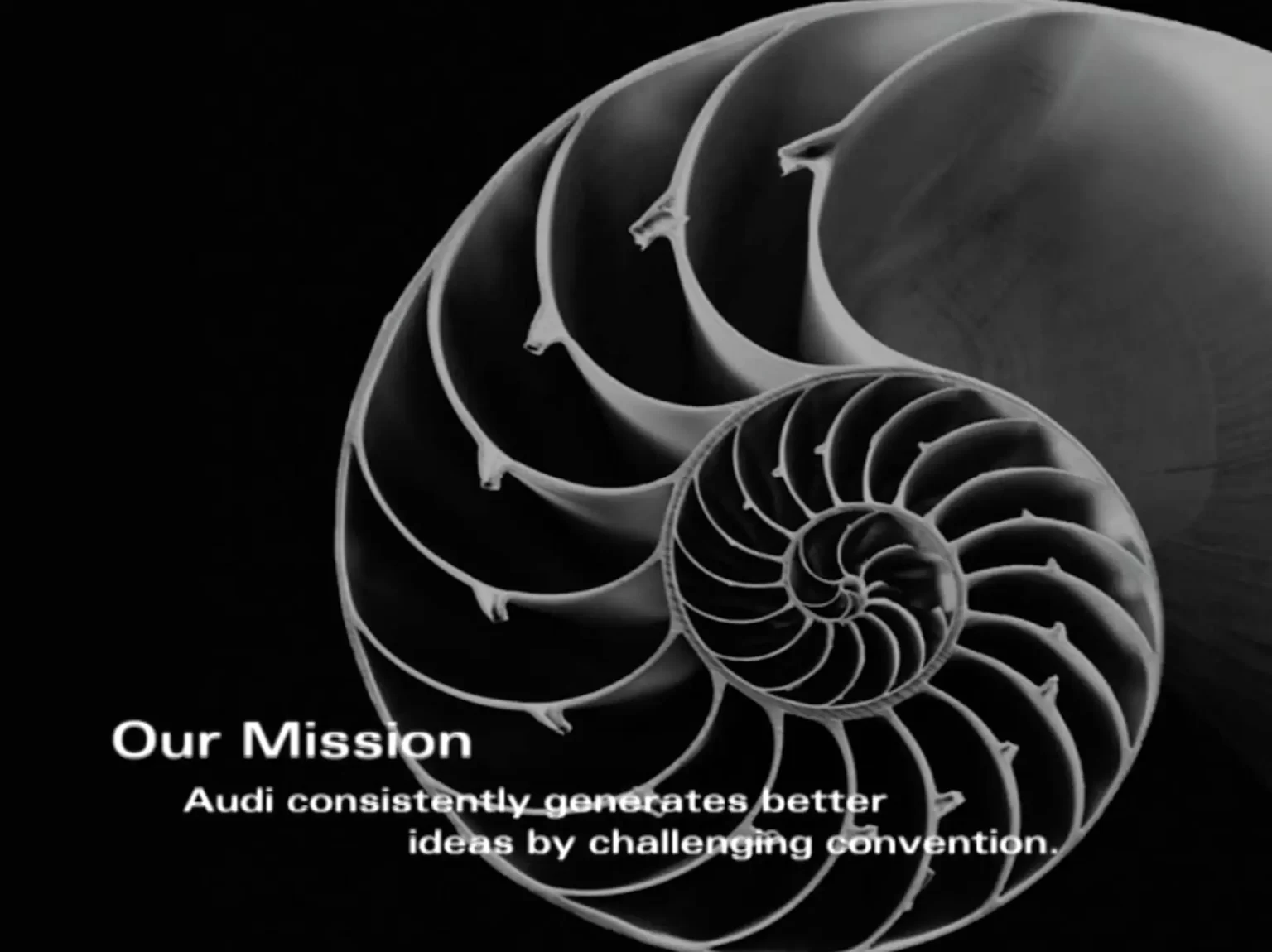 A nautilus shell with text overlay: "Our Mission - Audi consistently generates better ideas by challenging convention.