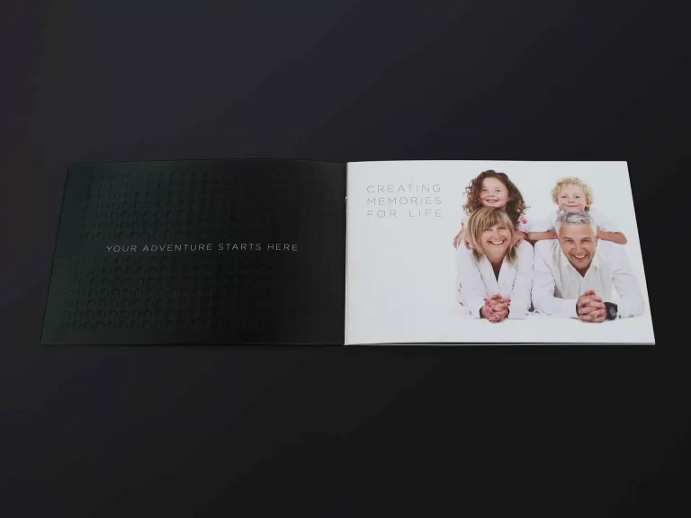 An open booklet displaying a family photo on the right page with the text "Creating Memories for Life." The left page contains the text "Your adventure starts here" on a dark background.