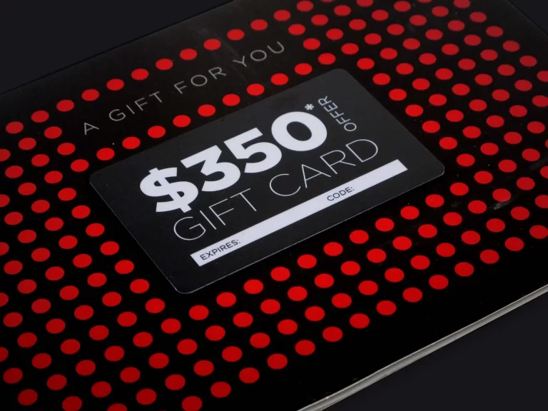 A gift card labeled "$350 Gift Card" with spaces for the expiration date and code. The card has a black and red polka dot design.