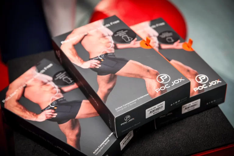 Three black boxes of PocJox active compression underwear featuring a partially visible male model wearing the product, displayed on a black surface.