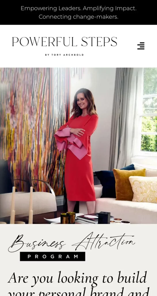 Woman in a red dress standing by a couch with colorful pillows in a stylish room; text on image reads "POWERFUL STEPS" and "Business Attraction Program.