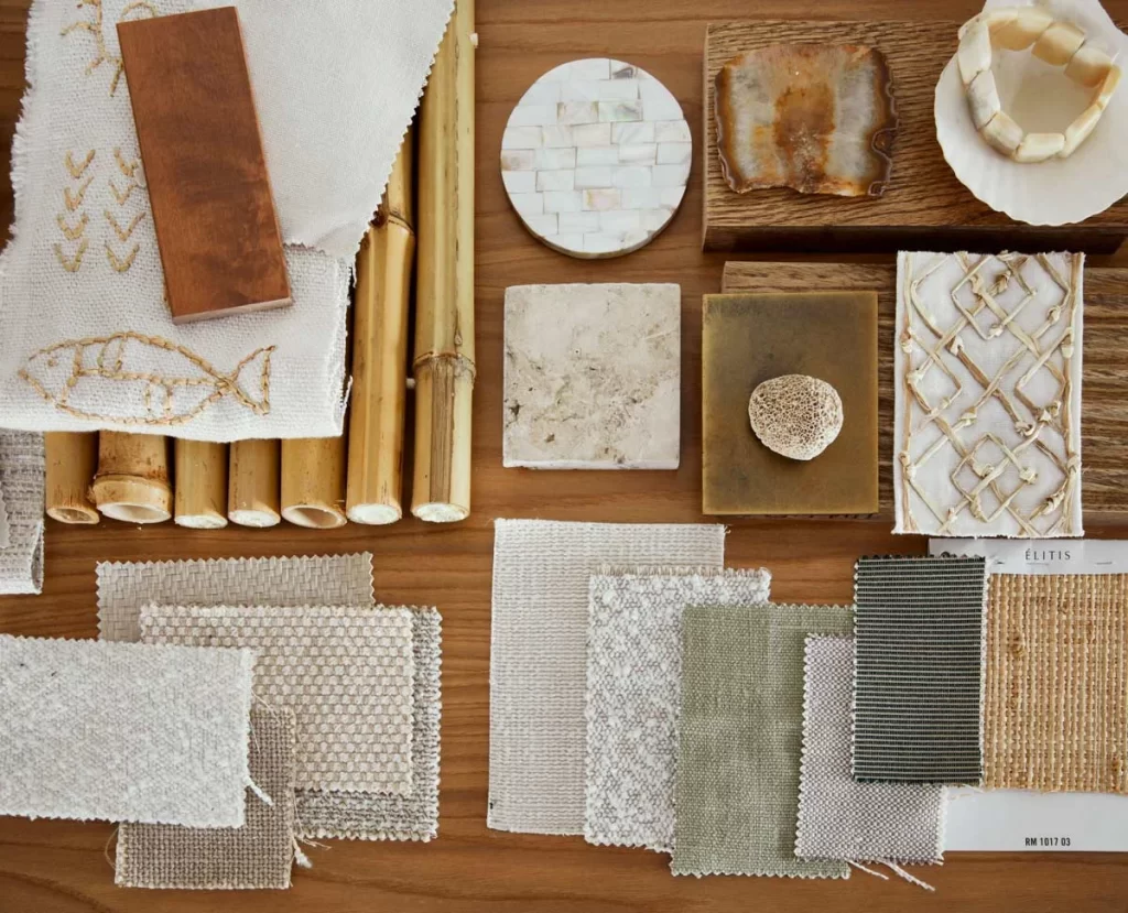 A selection of fabric and material swatches, bamboo pieces, tiles, and texture samples arranged neatly on a wooden surface.